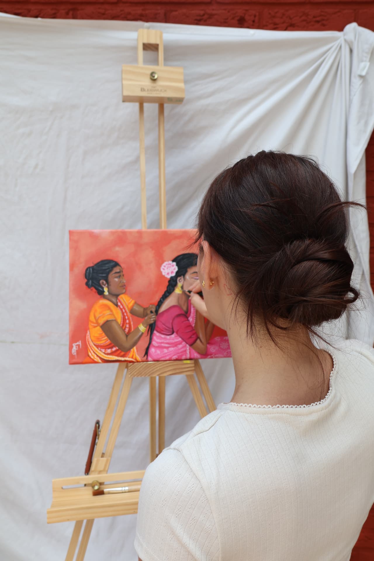 Lissy van Tol aan het werk aan een schilderij op ezel